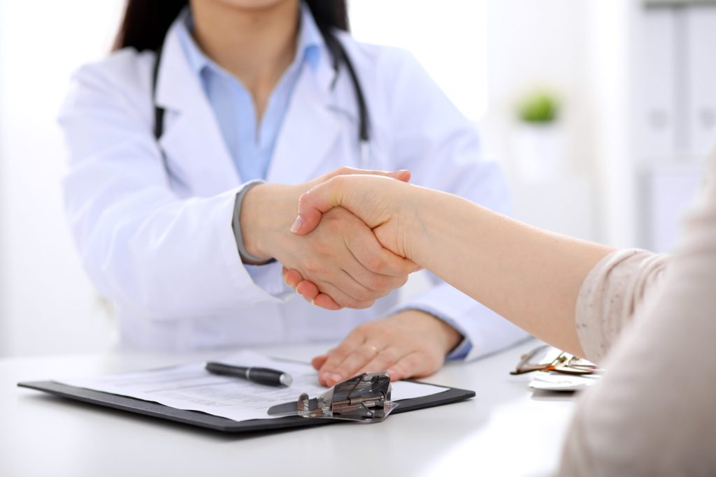 Doctor and patient shaking hands during a functional medicine consultation